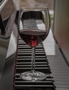 Glass of red wine on piano keyboard. Music and wine concept Royalty Free Stock Photo