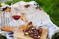 Glass with red wine and pieces of chocolate with nuts and raisins