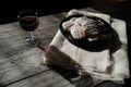 Glass of red wine and a plate of cookies on wooden table