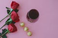 Wine glass with red roses and chocolates. Valentine`s Day Royalty Free Stock Photo