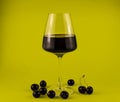 A glass of red wine with a scattering of cherries Royalty Free Stock Photo