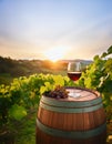 A glass of red wine sits in a wooden barrel next to a bunch of ripe grapes in the middle of a vineyard at sunset. Generative ai Royalty Free Stock Photo