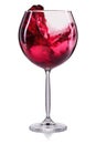 Glass of red wine with splash and drops on wineglass isolated on white background Royalty Free Stock Photo