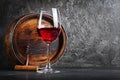 Glass with red wine for tasting and wooden barrel in dark cellar Royalty Free Stock Photo