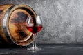 Glass with red wine for tasting and wooden barrel in dark cellar Royalty Free Stock Photo