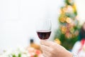 Glass of red wine for toasting in party with Christmas tree back Royalty Free Stock Photo