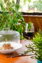 Glass of red wine and veal medallion with vegetables under transparent cap. Restaurant serving dish Royalty Free Stock Photo