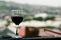 A glass of red wine with a view of the city, a glass on the balcony Royalty Free Stock Photo