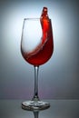 Glass of red wine with wave on blue background Royalty Free Stock Photo