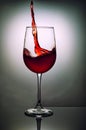 Glass of red wine with wave on grey background Royalty Free Stock Photo