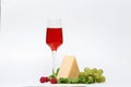 a glass of red wine on a white background with raspberry cheese and grapes Royalty Free Stock Photo