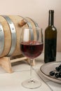 A glass of red wine with a wooden barrel and bottle Royalty Free Stock Photo