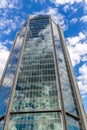 Glass reflective office buildings against blue sky with clouds and sun light