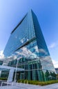 Glass reflective office buildings against blue sky with clouds and sun light