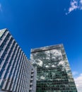 Glass reflective office buildings against blue sky with clouds and sun light Royalty Free Stock Photo