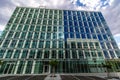 Glass reflective office buildings against blue sky with clouds and sun light Royalty Free Stock Photo