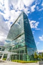 Glass reflective office buildings against blue sky with clouds and sun light