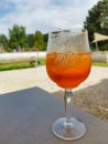 Glass of refreshing alcoholic drink Aperol Spritz in the park