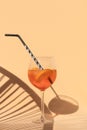 Glass of refreshing cold cocktail with soda drink, slices of orange and ice cubes on light background in sunlight with Royalty Free Stock Photo