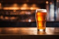 Glass of refreshing cold lager beer sitting on the wooden bar counter in a cozy pub Royalty Free Stock Photo