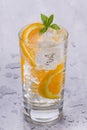 Glass of refreshing cold mineral water with pieces of orange Royalty Free Stock Photo