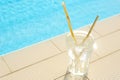 Glass of drink near swimming pool. Space for text Royalty Free Stock Photo