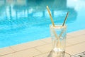 Glass of drink near swimming pool. Space for text Royalty Free Stock Photo