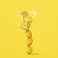 Glass of refreshing lemonade with ice on balanced lemons on a yellow background Royalty Free Stock Photo