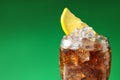 Glass of refreshing soda drink with ice cubes and lemon on green background, closeup. Space for text Royalty Free Stock Photo