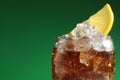 Glass of refreshing soda drink with ice cubes and lemon on green background, closeup. Space for text Royalty Free Stock Photo