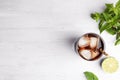 Glass of refreshing soda drink with ice cubes, mint and lime on white wooden table, flat lay. Space for text Royalty Free Stock Photo