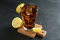 Glass of refreshing soda water with ice cubes and lemon on black table Royalty Free Stock Photo