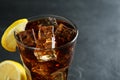 Glass of refreshing soda water with ice cubes and lemon slice on dark background, closeup Royalty Free Stock Photo