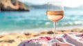 Glass of RosÃ© Wine on a Beach Towel Against a Blurry Seashore Background Royalty Free Stock Photo