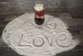 Glass with rose and expression of love in the sand Royalty Free Stock Photo