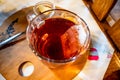 Glass of rose hip tea, tea bag, lemon and honey on table, closeup Royalty Free Stock Photo