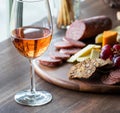 A glass of rose wine with a charcuteries board in soft focus in behind. Royalty Free Stock Photo