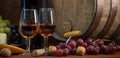 Glasses of rose wine cheeses grapesand barrel on brown wooden background Royalty Free Stock Photo