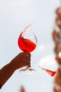 A glass of rose wine in hands with drops against the sky Royalty Free Stock Photo