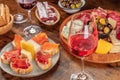 A glass of rose wine with sandwiches and a cheese and charcuterie platter