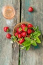 Glass of rose wine served with fresh strawberries on wooden background. Picnic outdoor with pink wine and berries Royalty Free Stock Photo