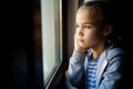 Through glass. sad teen girl look out of window outside. Royalty Free Stock Photo