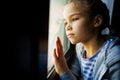 Through glass. sad teen girl look out of window outside. Royalty Free Stock Photo