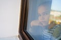 Through glass. sad teen girl look out of window outside. Royalty Free Stock Photo