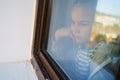 Through glass. sad teen girl look out of window outside. Royalty Free Stock Photo