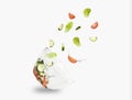 glass salad bowl in flight with vegetables: tomato, cucumber and leaf salad. Isolated on white background. healthy diet. Royalty Free Stock Photo