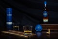 A glass of scotch in front of its blue case and beautiful bottle