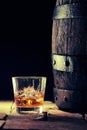 Glass of scotch on the rocks and an old oak barrel Royalty Free Stock Photo