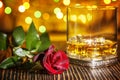 Glass of scotch whiskey and ice , red rose in holiday colorf Royalty Free Stock Photo