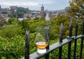 Glass of single malt scotch whisky and view from Calton hill to park and old parts of Edinburgh city in rainy day, Scotland, UK Royalty Free Stock Photo